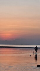 Fototapeta premium Man fishing in the sea during sunset
