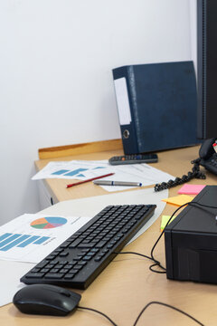 Busy office desk with documents and computer hardware