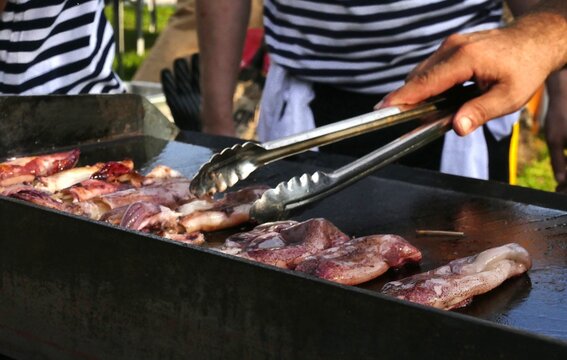 Fisherman grilled fresh squid from the sea on barbecue smoked, healthy Mediterranean food