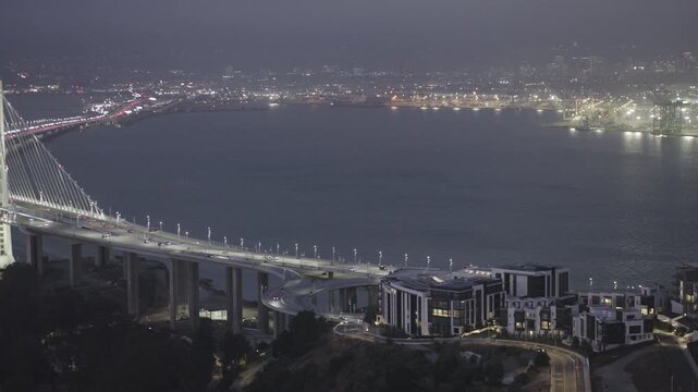 Cinematic Aerial Shot Over Stormy San Francisco Bay With Bridge Tunnel Portal and Multilane Road at Night
