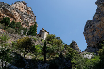 Fototapeta premium Mountain Chapel Nestled Between Dramatic Limestone Cliffs in Provence, France.