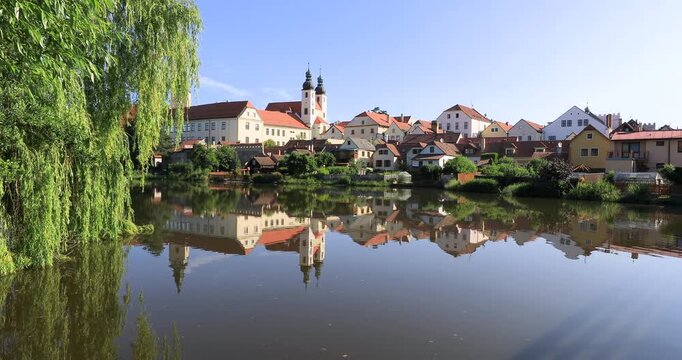 4K  locked off motion view of historic buildings and houses in the pond, the buildings lining the shore of the pond creating a picturesque scene with their reflections in the water, Telc, Europe