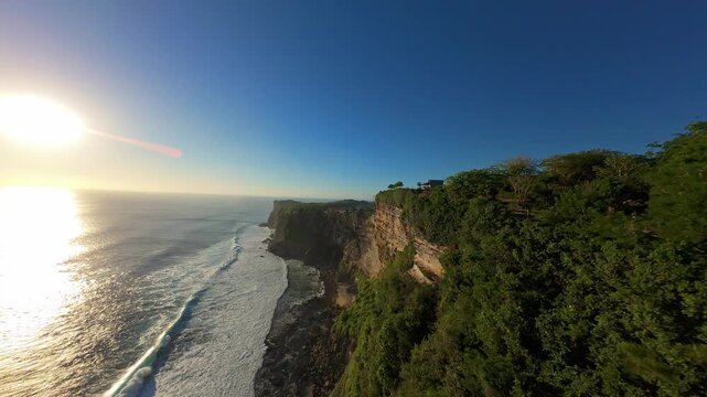 Smooth Aerial Flight Along Karang Boma Cliff At Sunset In Bali, Wide Angle View Of Towering Coastal Cliffs Above Ocean Waves And Golden Horizon, Freedom And Exploration