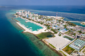 Fototapeta premium Aerial drone view of Maafushi, one of the inhabited islands of Kaafu Atoll in the Maldives. Maafushi island is popular for budget travel in Maldives.