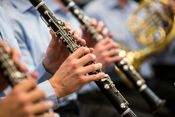 Fototapeta premium Hands playing a clarinet in an orchestra, close-up with blurred background.