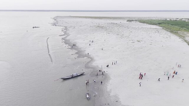 KUSHTIA, BANGLADESH &ndash; JUNE 27, 2026: Aerial drone footage showing people walking across the sandy riverbank at the Gorai Confluence, where the Gorai River meets the Padma River.