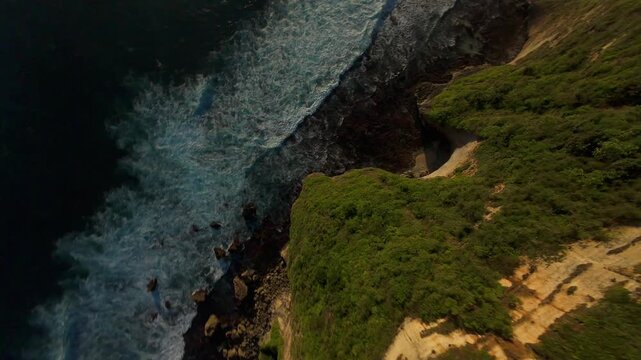 Extreme FPV Drone Dive Above Karang Boma Cliff At Sunset, First Person Flight Following Ocean Waves Along Rocky Coastline, Freedom And Discovery