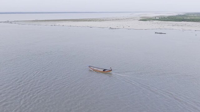 Professional 4K drone orbit shot focusing on a traditional wooden boat on the Padma River in Kushtia, Bangladesh.