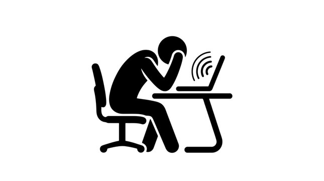 Frustrated man sitting at desk with laptop.