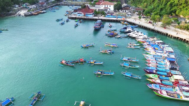 Aerial Drone View of Traditional Fishing Boats Moored at Sadeng Fishing Port During Sunset, Yogyakarta, Indonesia
