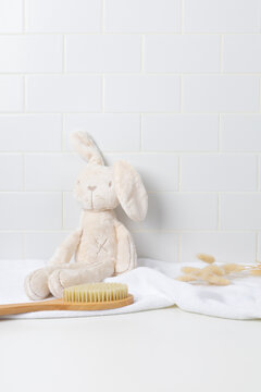 Baby product mockup background with cute plush bunny toy on white bathroom counter. Empty space for newborn skincare, shampoo, or baby cosmetic display.