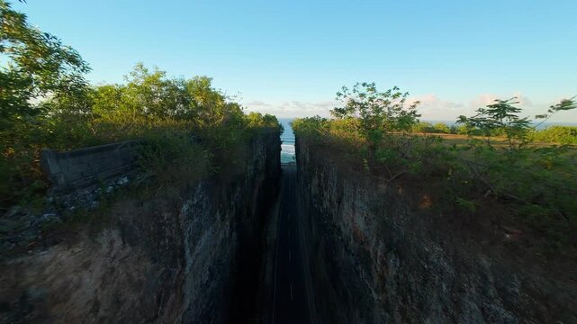 Smooth Cinematic Aerial Flight Through Narrow Cliff Corridor At Pantai Tanah Barak Toward Ocean Horizon, Sunrise Light Over Tropical Landscape, Adventure And Freedom