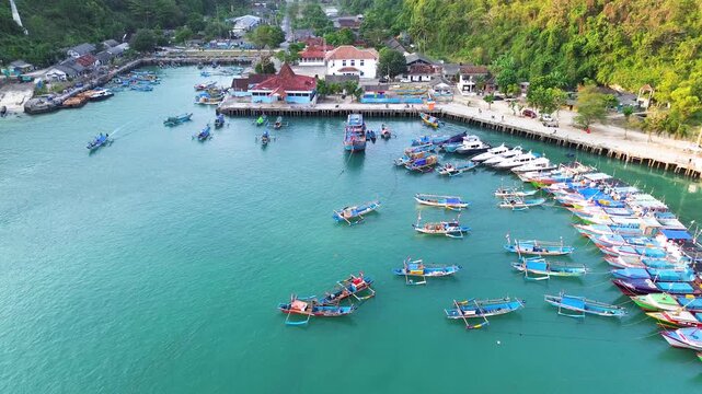 Aerial Drone View of Traditional Fishing Boats Moored at Sadeng Fishing Port During Sunset, Yogyakarta, Indonesia