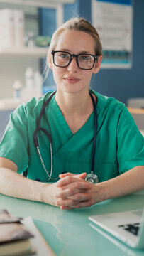 Portrait of female doctor sitting at desk in office clinic