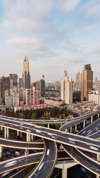 Cityscape vertical time lapse of busy elevated road intersection with commuters during daytime, Asia, China, Shanghai

