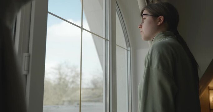 Thoughtful Girl Stand Near Window and Look Outside. 4K 10-bit