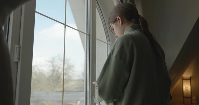 Thoughtful Girl Stand Near Window and Look Outside. 4K 10-bit