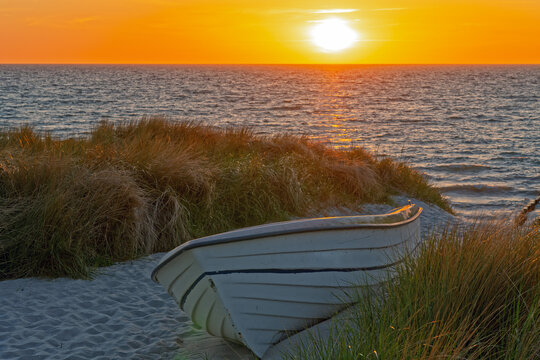 Fischerboot mit Sonnenuntergang am Strand in den D&uuml;nen