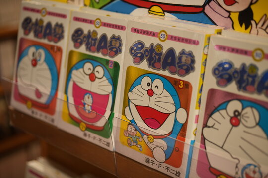 A row of Doraemon comic books displayed on a store shelf.
