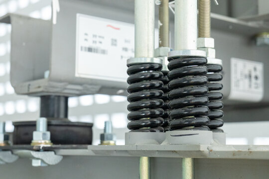Industrial spring metal coil vibration isolator mechanical equipment closeup black spring steel component engineering machinery shock absorber heavy duty support structure industrial part hardware