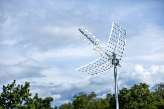 Outdoor antenna metal technology communication sky signal reception broadcast wireless Modern outdoor antenna with metal grid design stands against cloudy sky providing reliable signal reception