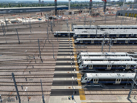 Aerial view of Old Oak Common Elizabeth Line Depot featuring multiple commuter trains parked on parallel tracks within the expansive railway facility in London, England, United Kingdom.