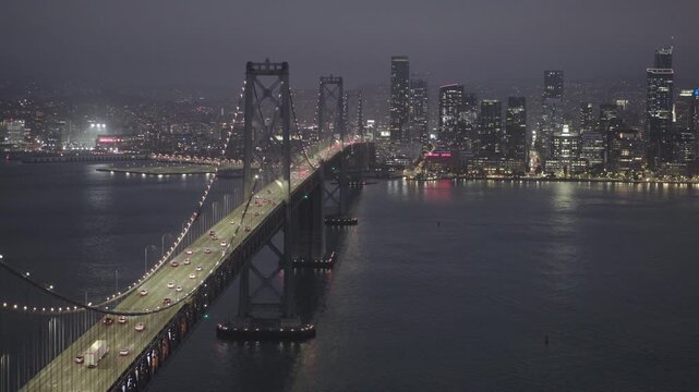 Cinematic Aerial Shot Over San Francisco Bay Bridge With Traffic and Skyline At Night 