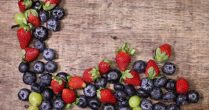 Fresh ripe Blueberry strawberry grape macro closeup on wood dark white background slide move organize