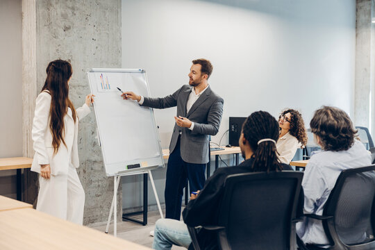 Business professionals presenting financial charts during office meeting