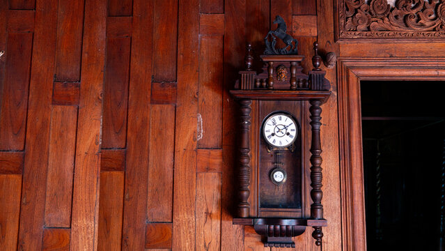 A vintage clock on an antique wooden wall.