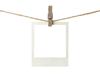 Empty vintage polaroid photo frame hanging on a wooden clothespin and rope © Raja