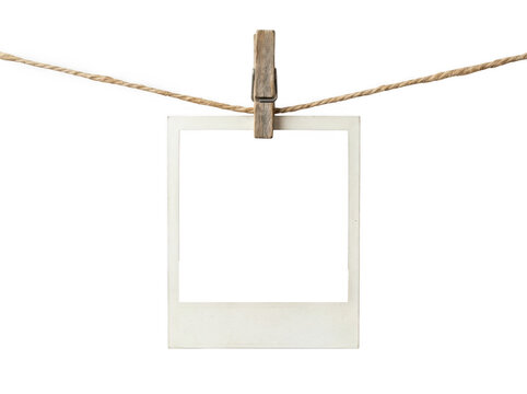 Empty vintage polaroid photo frame hanging on a wooden clothespin and rope