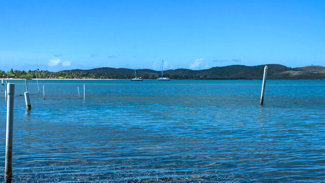 Scenic coastal view of Boqueron Bay at Cabo Rojo with wooden pilings in the foreground