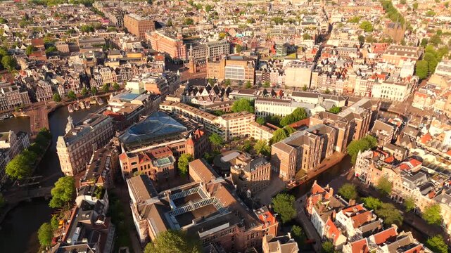 High altitude drone panorama captures Amsterdam historic center from above with winding canals and dense urban rooftops