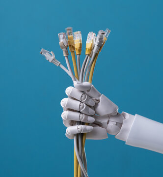 Robot hand holding a bunch of ethernet lan cables on blue background.