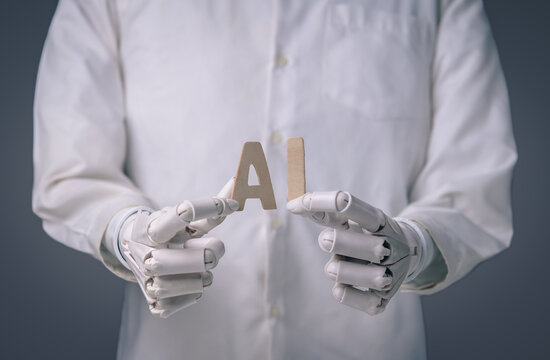 Robot hands holding wooden letters forming word AI on gray background.