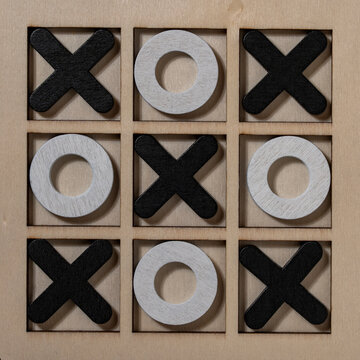 Wooden tic tac toe board game with zero result concept. Top view of finished tic-tac-toe game with wooden crosses and noughts. Metaphor for endless competition, draw result or business strategy