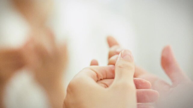 Girl gently massages her cuticles with a softener, carefully tending to her fingertips. This meticulous process, integral to a home manicure, leaves her nails and skin rejuvenated and healthy-looking