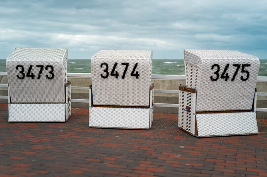 Sylt, Germany. Beach chairs on the promenade at Westerland on a cloudy day.