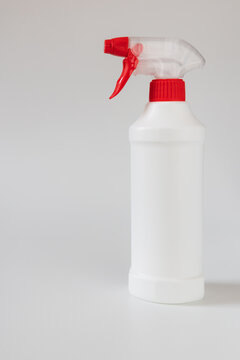 White plastic spray bottle with red trigger isolated on light background