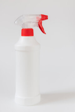 White plastic spray bottle with red trigger isolated on light background