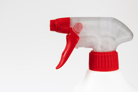 White plastic spray bottle with red trigger isolated on light background