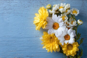 Obraz premium A vibrant bouquet of daisies and yellow blooms rests on a textured, faded blue wooden surface
