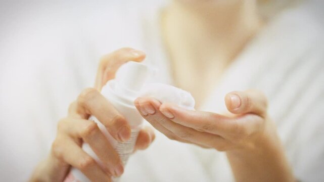 A girl prepares to wash her face with a delicate cleansing foam from a bottle, gently releasing a small amount to softly cleanse and refresh her skin, maintaining its natural balance and texture