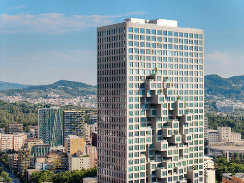 Aerial view of Downtown One skyscraper featuring a unique pixelated facade with recessed balconies, surrounded by the urban landscape of Tirane, Qarku i Tiranes, Albania.