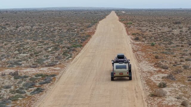 Driving through the desert landscape of Baja California with a teardrop camper trailer for an overland camping trip.