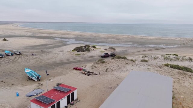 Suv pulls a teardrop camper trailer through a fishing village during an overland trip near Guerrero Negro Baja California Mexico.