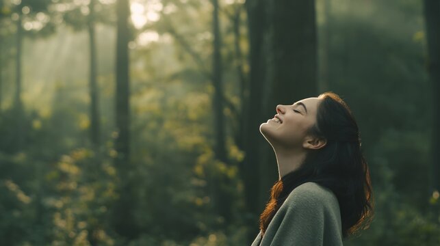 Peaceful woman embracing a tranquil morning in nature with her eyes shut and a soft smile on her face