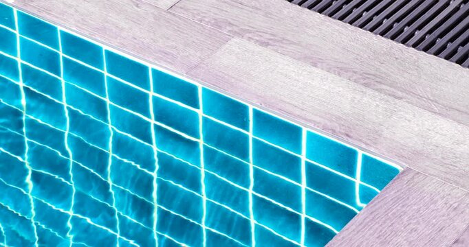 swimming pool edge with clear blue water, tiled reflections, and relaxing resort atmosphere. ideal for travel, leisure, luxury, and lifestyle concepts, close-up