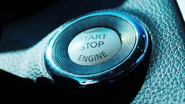 Car engine start stop button on black textured dashboard